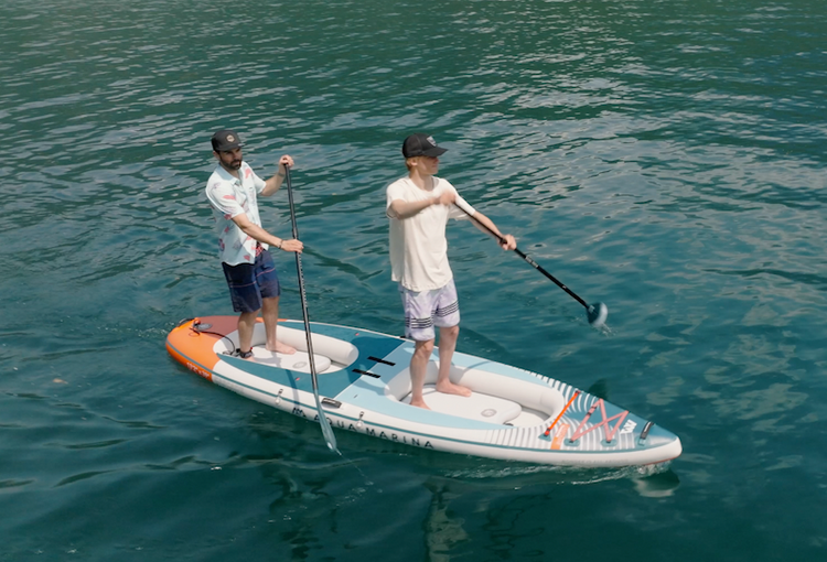 Hybrid kayak and paddleboard rental gliding across Flathead Lake. Convertible inflatable iSUP combo kits available from MontanaBoarders.com or purchase at E-Boarders.com.