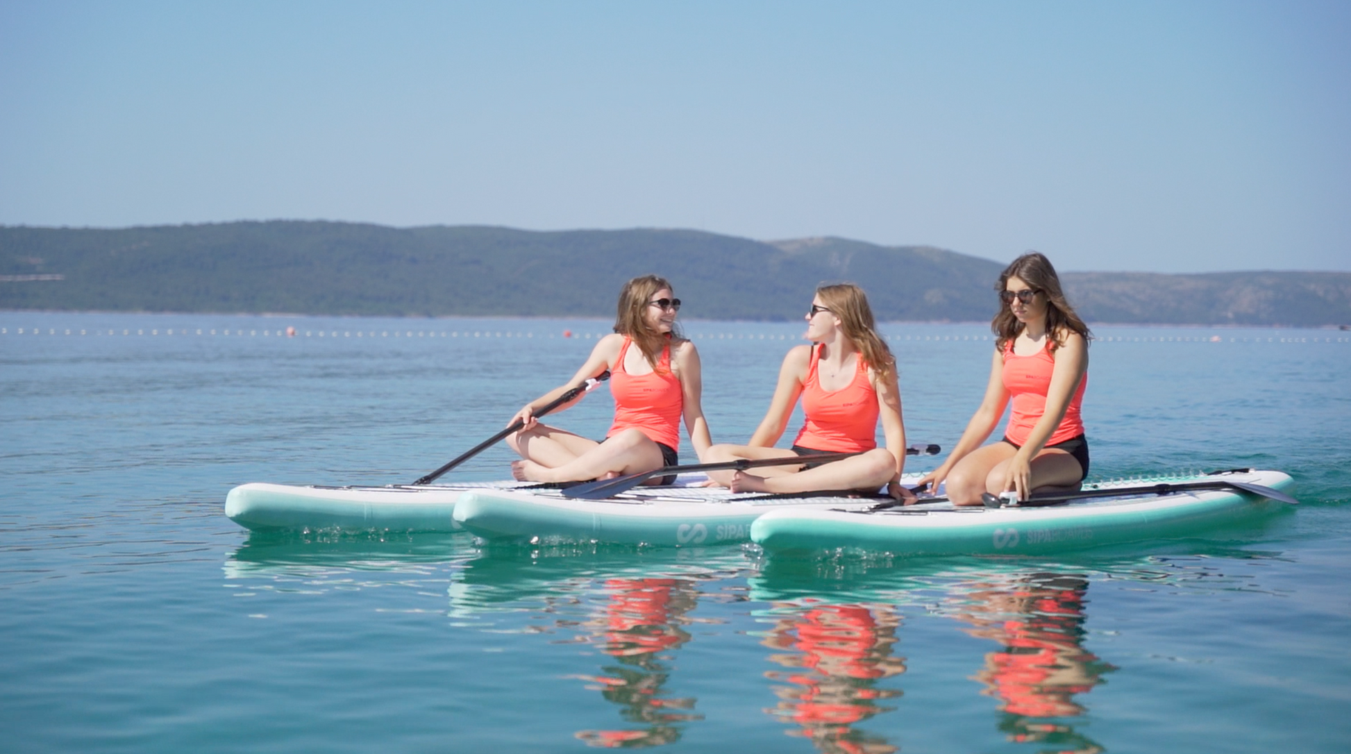 Three girls on three SipaBoards self-inflating electric paddleboard rental with built-in propulsion and Bluetooth remote, delivered to Flathead Valley lakefronts.