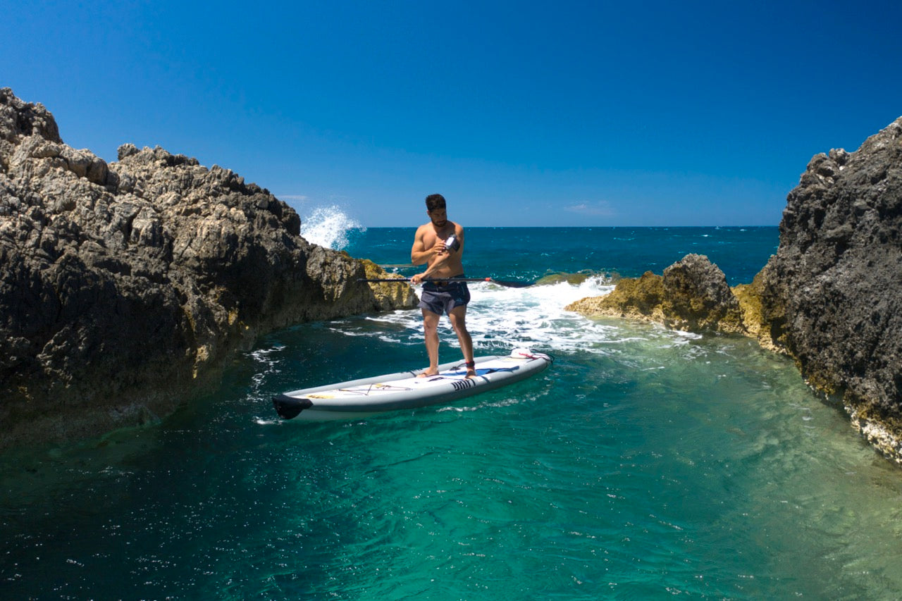 Paddler on inflatable paddleboard isup Drift by Aqua Marina with fishing pole. Rent fishing gear from MTBoarders.com with delivery included. Or buy now from e-boarders.com