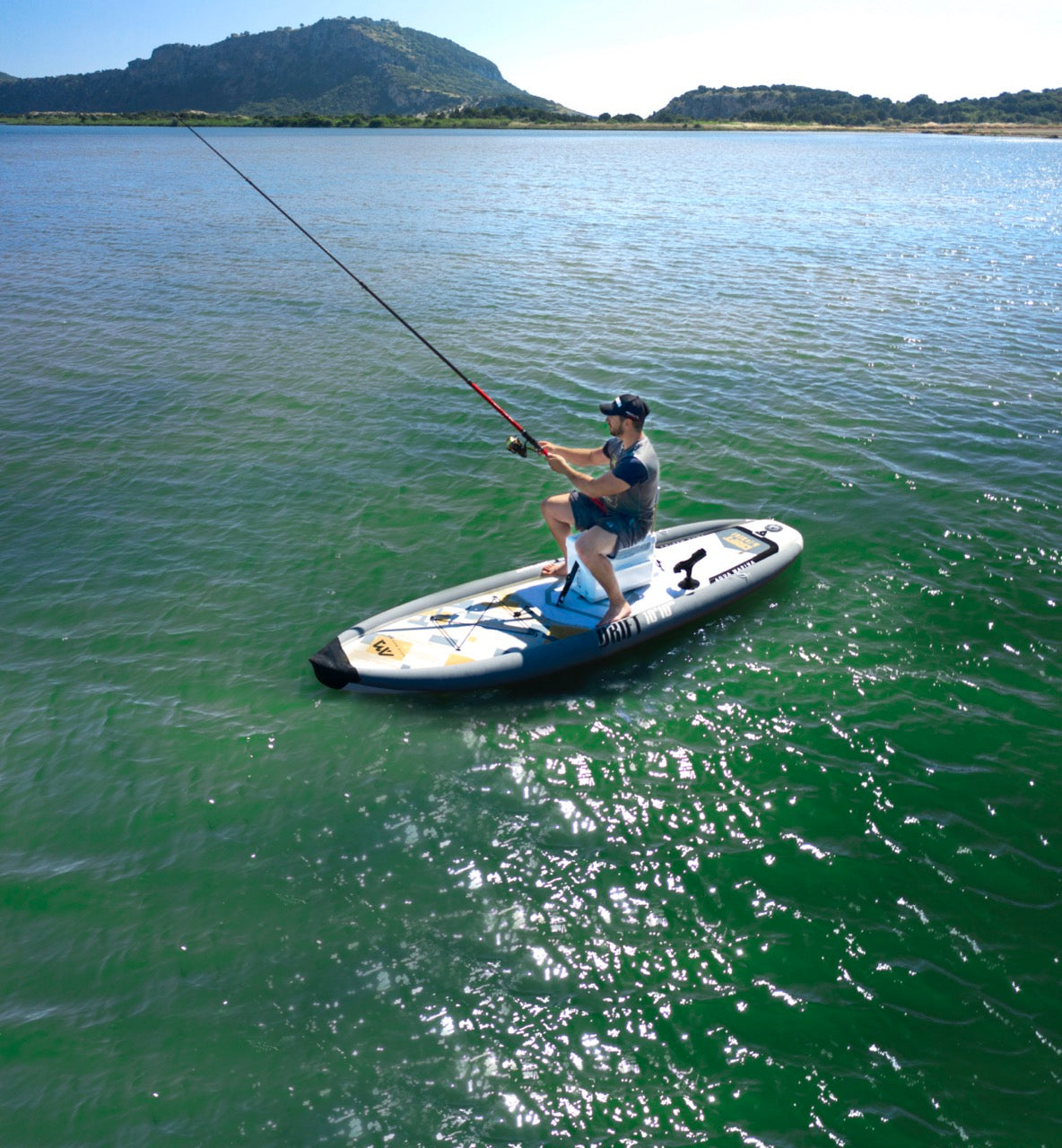 Fisherman on inflatable paddleboard isup casting a line on Flathead Lake | Rent fishing gear from MTBoarders.com with delivery included. Or buy now from e-boarders.com