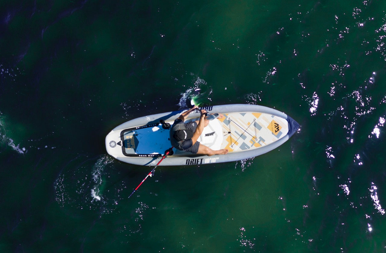 Fisherman on inflatable paddleboard isup Drift by Aqua Marina with fishing pole. Rent fishing gear from MTBoarders.com with delivery included. Or buy now from e-boarders.com