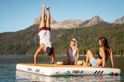 Handstand on Inflatable lake furniture bundle rental with floating dock, lounge chairs, and table—delivered to waterfront properties in Flathead Valley, Montana. Rent from MontanaBoarders.com purchase from flagship partner eboarders.com