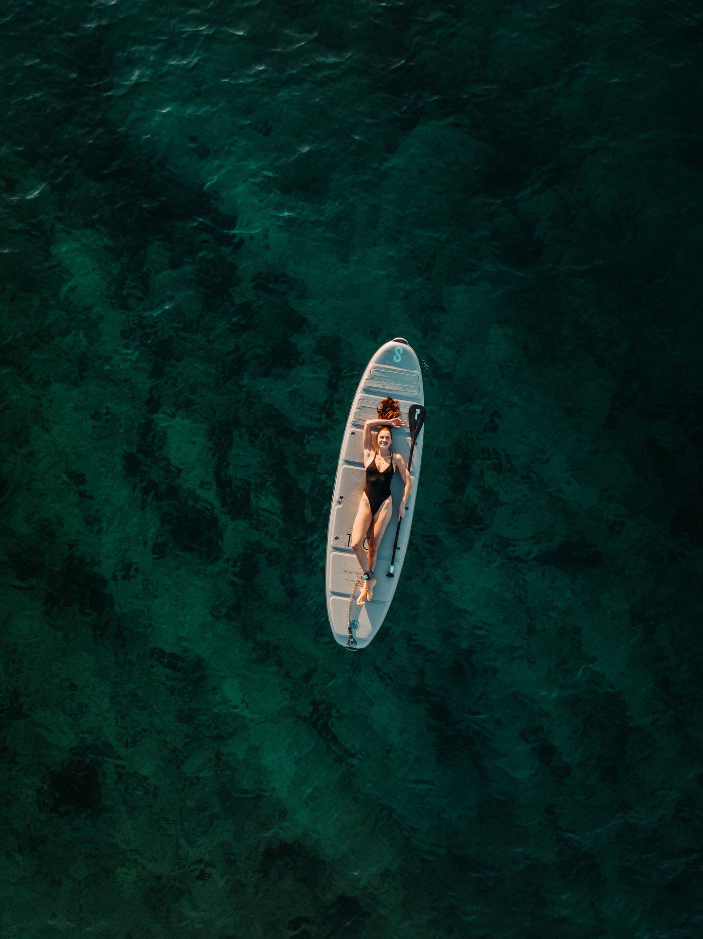 Lady laying on SipaBoards self-inflating electric paddleboard rentals delivered to Flathead Valley lakefronts.
