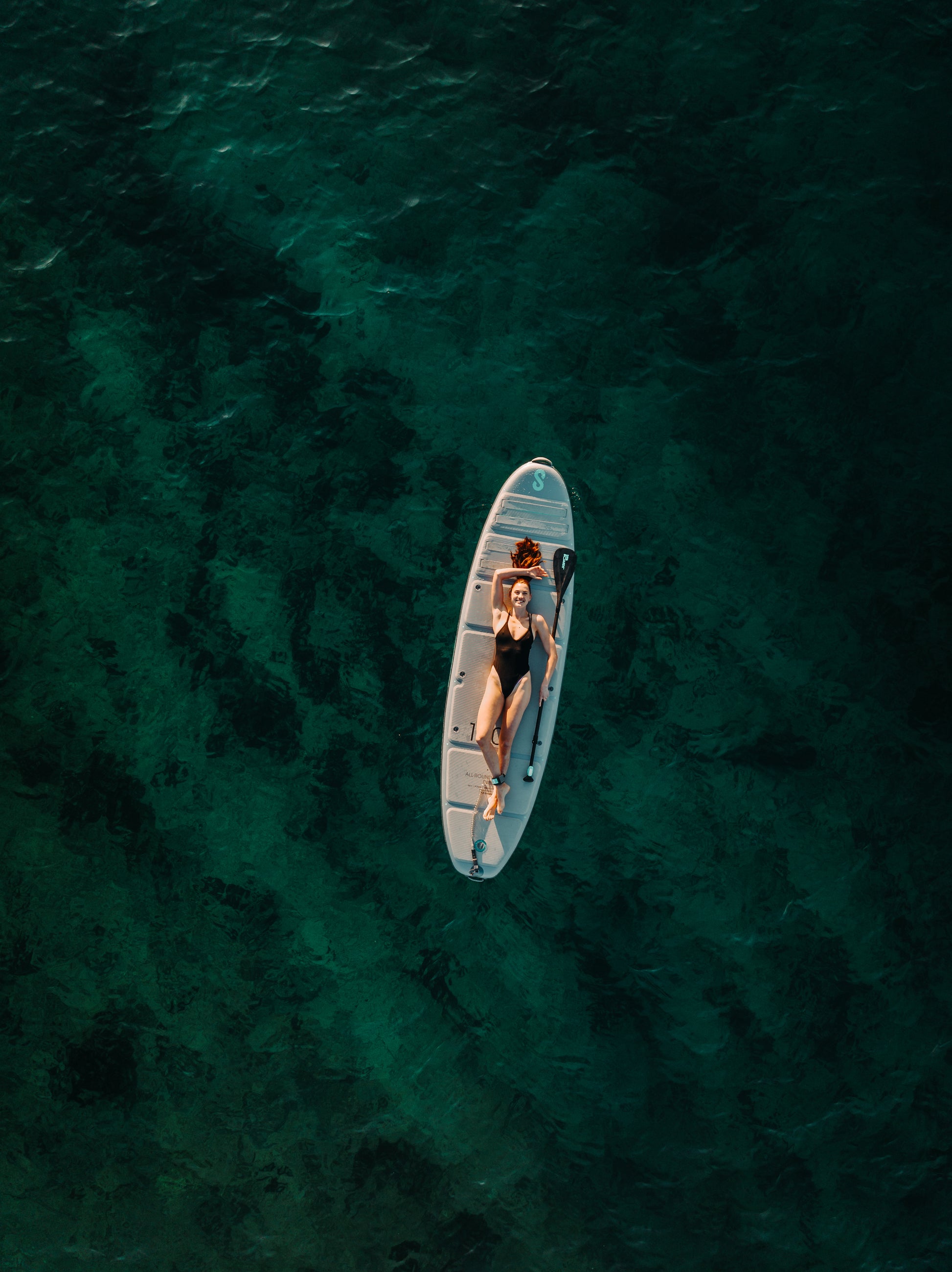 Lady laying on SipaBoards self-inflating electric paddleboard rentals delivered to Flathead Valley lakefronts.