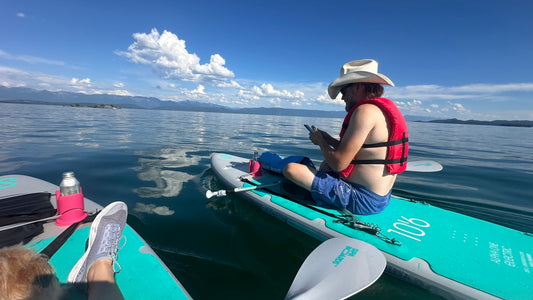 Person on a SIPA electric paddleboard with a clear blue sky and calm water on Flathead Lake, Montana